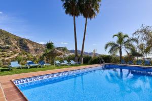 a swimming pool with chairs and palm trees at Group Villa 14 Pool Beach 10 minute in Frigiliana