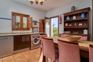 a kitchen with a counter and a table with chairs at Group Villa 14 Pool Beach 10 minute in Frigiliana