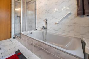 a bathroom with a white tub and a toilet at Ferienhaus Am Waldrand in Wietze +22 photos