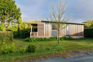 a small house in a yard with a tree at Chalet 35m2 - Molène in Plouhinec