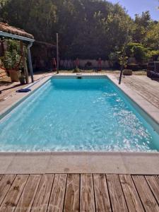 a large swimming pool with a wooden deck at La Farigoulette in Aniane
