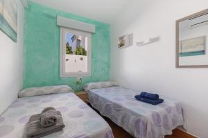 a room with two beds and a window at Villa Rose in Cala Blanca +37 photos
