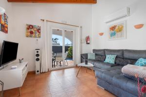a living room with a couch and a television at Villa Rose in Cala Blanca
