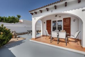 a patio with a table and chairs in a house at Villa Rose in Cala Blanca