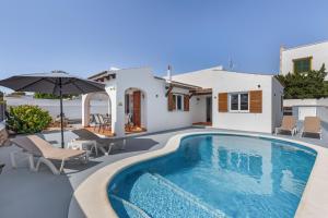 a villa with a swimming pool and a house at Villa Rose in Cala Blanca