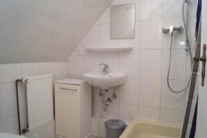 a white bathroom with a sink and a shower at Alte Schule in Bad Wildungen +11 photos