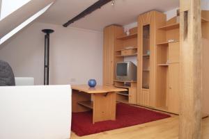 a room with a desk with a tv and shelves at Alte Schule in Bad Wildungen