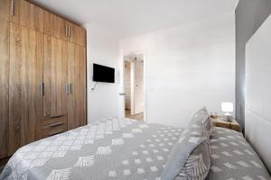 a bedroom with a bed and a wooden cabinet at Los Pocillos in Los Pocillos +16 photos