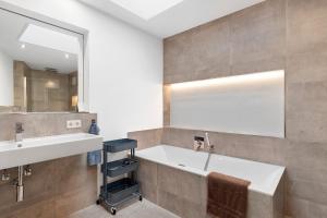 a bathroom with a tub and a sink and a mirror at Hygge Home Schwarzwald in Villingen-Schwenningen +26 photos