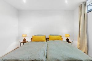 a bedroom with a large bed with two yellow pillows at Hygge Home Schwarzwald in Villingen-Schwenningen