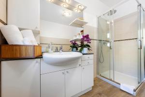 a white bathroom with a sink and a shower at Alpenglow Maison Lugon in Saint-Christophe +24 photos