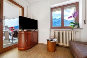 a living room with a flat screen tv on a cabinet at Alpenglow Maison Lugon in Saint-Christophe
