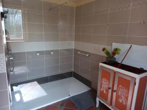 a bathroom with a shower with a bench in it at Les Vallons du Lot in Gorses