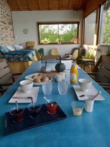 a blue table with bowls and plates of food on it at Les Vallons du Lot in Gorses +3 photos