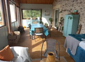 a living room with a blue table and chairs at Les Vallons du Lot in Gorses