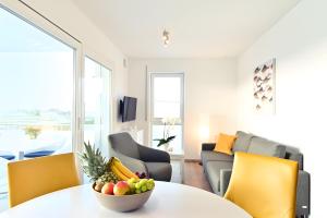 a living room with a table with a bowl of fruit on it at Dinkelbach Traumblick 3 C in Hengnau
