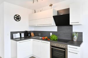 a kitchen with white cabinets and a black counter top at Dinkelbach Traumblick 3 C in Hengnau +13 photos