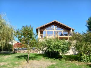 a house with a wooden roof on top of a yard at Les Vallons du Lot in Gorses