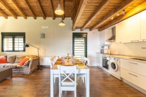 a kitchen and living room with a table and chairs at La Morada De Piedralaves in Piedralaves