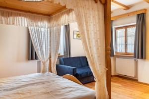a bedroom with a bed and a blue chair at Schreiberhof Landhaus in Laion