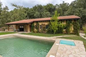 a house with a swimming pool in front of a house at La Morada De Piedralaves in Piedralaves