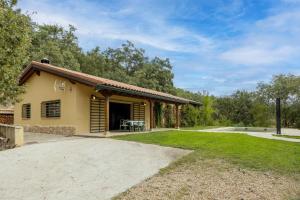 a small yellow house with a patio and grass at La Morada De Piedralaves in Piedralaves
