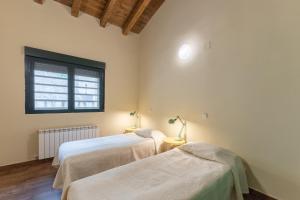 two beds in a room with a window at La Morada De Piedralaves in Piedralaves +25 photos