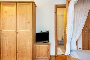 a bedroom with a bed and a tv on a wooden cabinet at Schreiberhof Landhaus in Laion