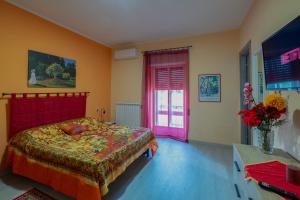 a bedroom with a bed with a red headboard and a window at Casa Monet 90 wifi-parking in Capodimonte