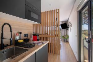 a kitchen with a sink and a desk with a keyboard at Tiny House in São Brás de Alportel