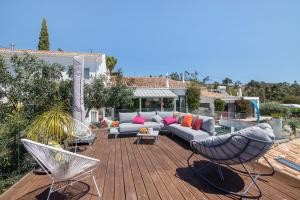 a patio with a couch and chairs on a wooden deck at Tiny House in São Brás de Alportel
