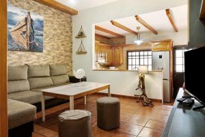 a living room with a couch and a table and a kitchen at El Rinconcito del Faro in Gáldar