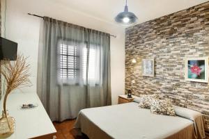 a bedroom with a bed and a brick wall at El Rinconcito del Faro in Gáldar