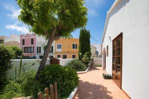 a courtyard with a tree and some buildings at Villa Republica Argentina in Ciutadella