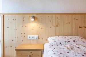 a bedroom with a wooden headboard with a bed and a wooden table at Thusnelda Apartment A in Siusi