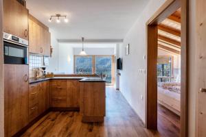 a kitchen with wooden cabinets and a large window at Thusnelda Apartment A in Siusi