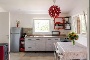a kitchen with red cabinets and a table with a vase of flowers at Ruralholidays in Calimera