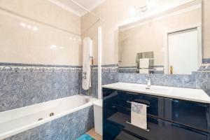 a bathroom with a white tub and a sink and a bath tubermott at Cas Momio in Palma de Mallorca +14 photos