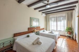 a bedroom with two beds and a window at Casa Rural La Teja in Marchena +49 photos