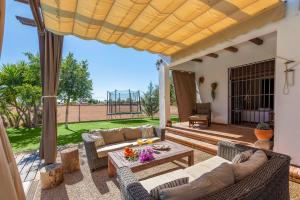 a patio with couches and a table on a deck at Casa Rural La Teja in Marchena