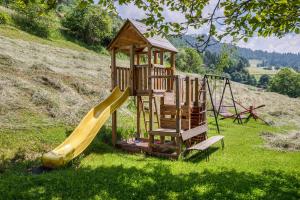 a wooden playground with a slide and a slideintend at Appartements Gabrielli Marie in Trodena