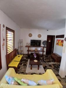 a living room with a couch and a table at Roses hostel e pousada in Pipa