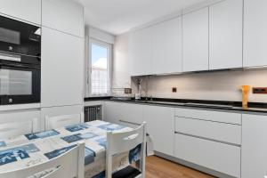 a kitchen with white cabinets and a table with chairs at Comarca del Sella in Arriondas