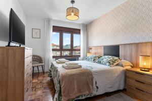 a bedroom with a large bed and a television at Comarca del Sella in Arriondas
