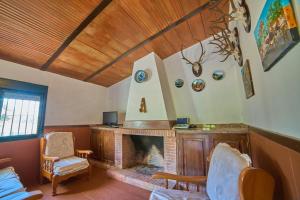 a living room with a fireplace and a chair at Huerta del Sol in Aracena
