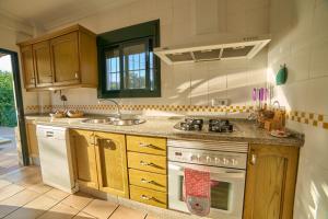 a kitchen with a stove and a sink at Huerta del Sol in Aracena