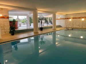 a large swimming pool in a building with a pool at Guck zum Bodensee in Uhldingen-Mühlhofen