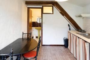 a dining room with a table and a kitchen at Studio Tamburine Xaharra in Ainhoa
