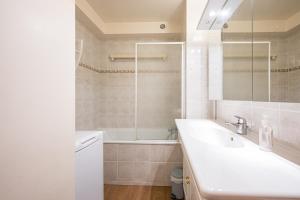 a bathroom with a sink and a tub and a mirror at Lauziere centre 6 couchages in Saint-François-Longchamp +13 photos