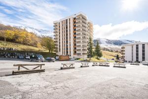 a parking lot with benches in front of a building at Lauziere centre 6 couchages in Saint-François-Longchamp